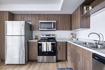 A modern kitchen with a white refrigerator, stove, and oven.at Traditions at Hazelwood, Portland, OR
